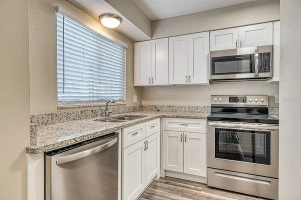 a kitchen with stainless steel appliances granite countertop a stove microwave and oven