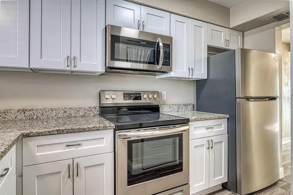 a kitchen with appliances cabinets and a counter top space