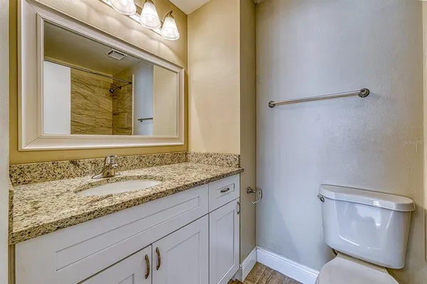 a bathroom with a granite countertop sink and a mirror