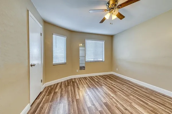 a view of an empty room with window and wooden floor