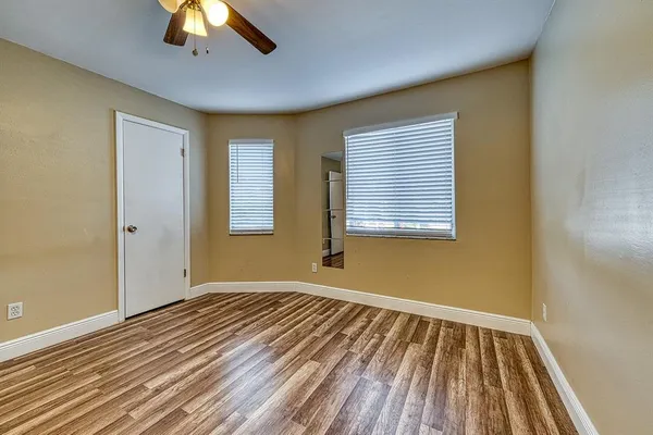 a view of empty room with wooden floor