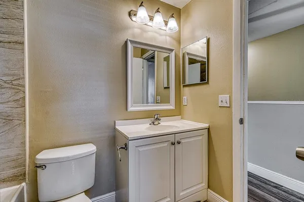 a bathroom with a sink a toilet and mirror