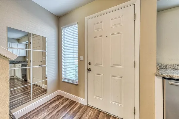 a view of a hallway with wooden floor and a bathroom