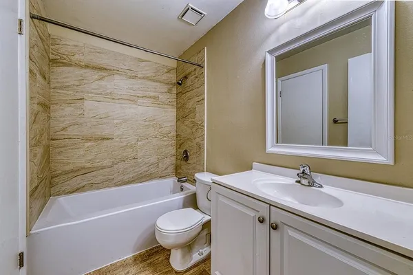 a bathroom with a sink a toilet a mirror a bathtub and shower