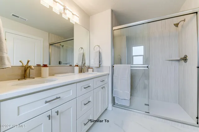 a spacious bathroom with a shower sink and mirror