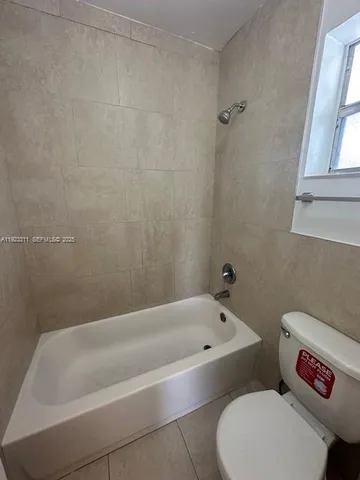a bathroom with a bathtub and toilet