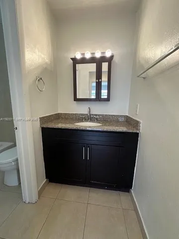 a bathroom with a granite countertop sink and a mirror