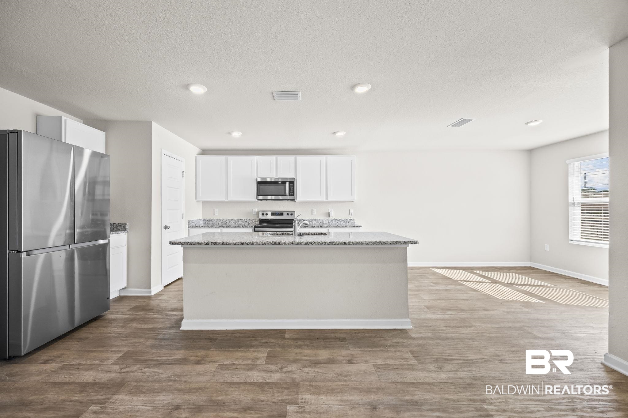 3090 Camino Real Loop Lillian, AL 36549 - Photo 14 of 29 Kitchen featuring appliances with stainless steel finishes, white cabinets, light stone counters, dark wood finished floors, and recessed lighting