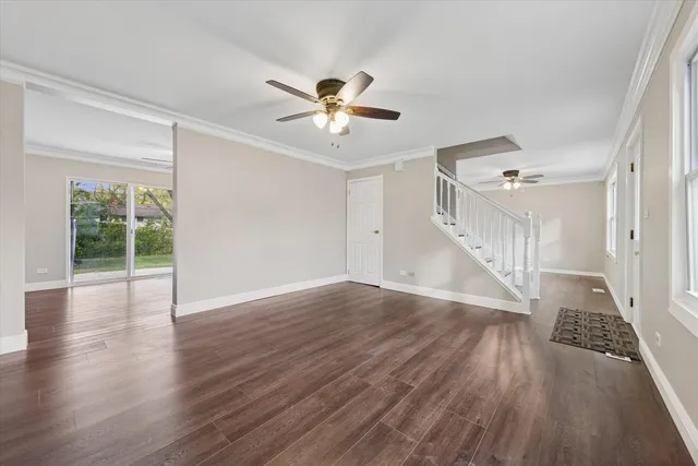 a view of a livingroom with wooden floor and a ceiling fan