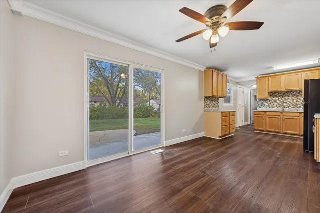 a view of a big room with wooden floor a ceiling fan and windows
