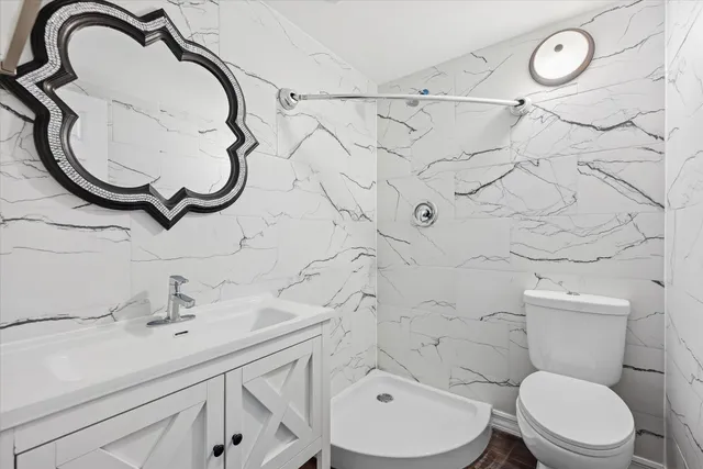 a bathroom with a sink a toilet and a shower