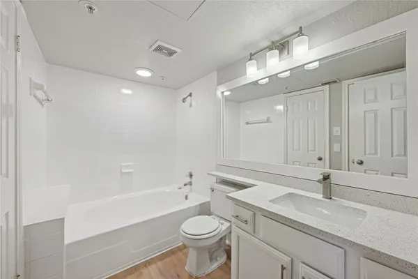 a bathroom with a sink a toilet a mirror and shower