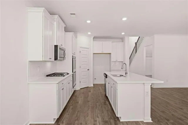 an empty room with wooden floor fireplace and windows