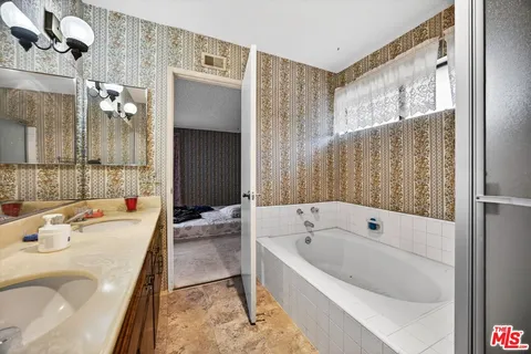 a bathroom with a tub sink and mirror