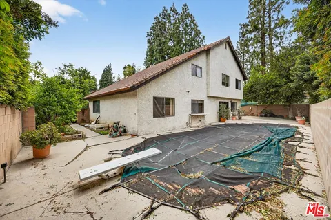 a view of a house with backyard and sitting area