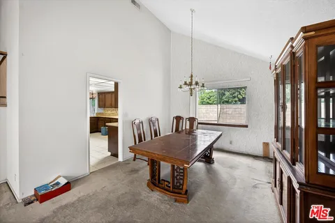 a dining room with furniture and a floor to ceiling window