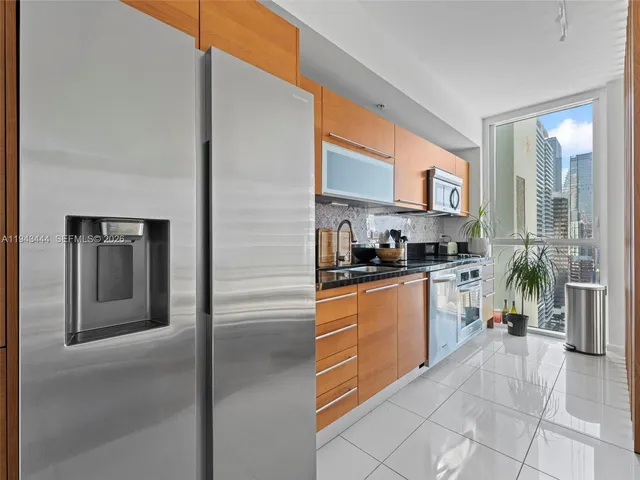 a kitchen with stainless steel appliances granite countertop a refrigerator and a sink