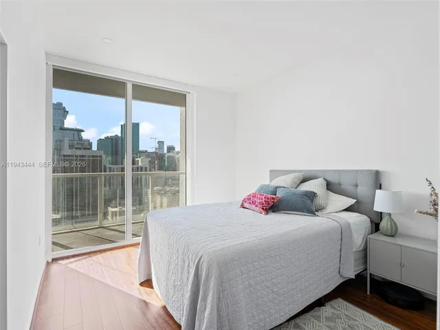 a bedroom with a bed and a large window