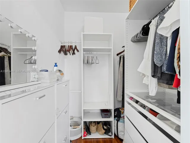 a view of walk in closet with clothes and shoes