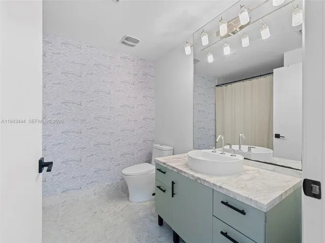 a bathroom with a sink a toilet and mirror