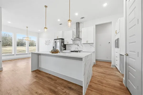 a kitchen with kitchen island granite countertop a sink a counter top space and stainless steel appliances