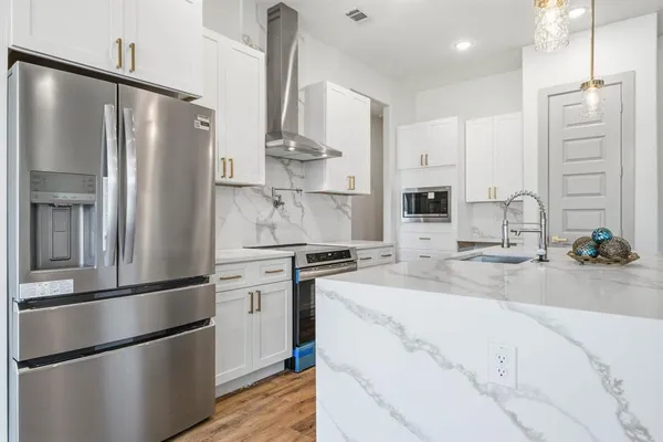 a kitchen with stainless steel appliances a refrigerator sink and microwave