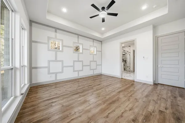 a view of empty room with wooden floor and window