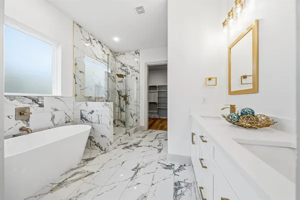 a bathroom with a bathtub sink and mirror