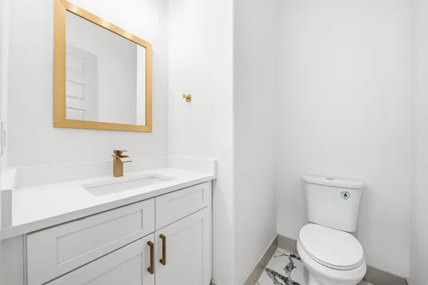 a bathroom with a toilet a sink and mirror