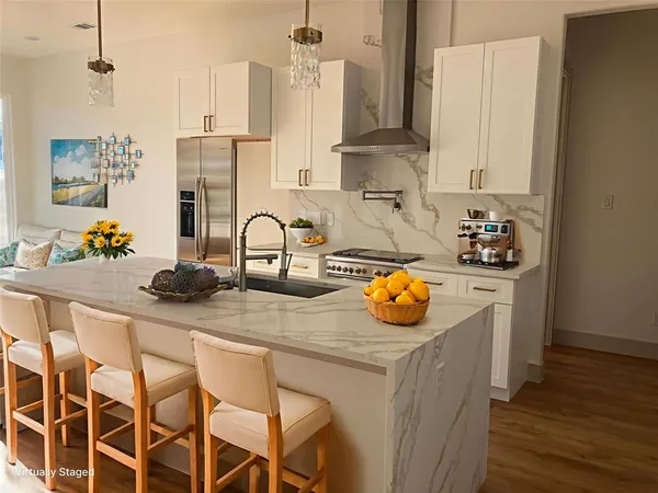a kitchen with stainless steel appliances kitchen island granite countertop a sink and cabinets