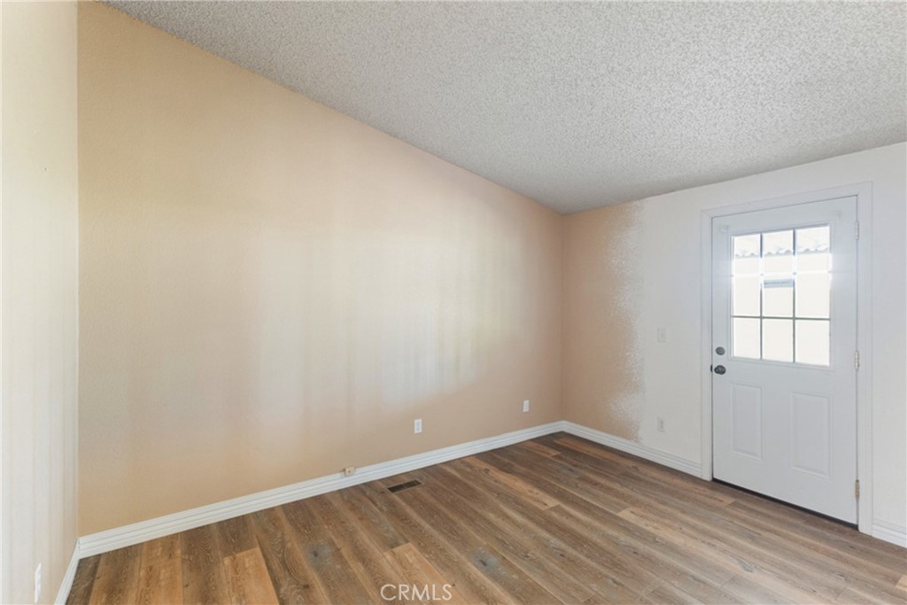 33105 Santiago Road, Unit 149 Acton, CA 93510 - Photo 18 of 28 an empty room with wooden floor and windows