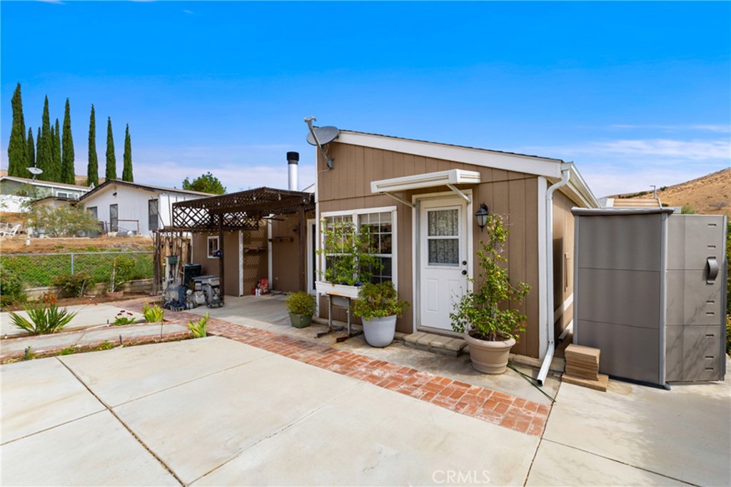 33105 Santiago Road, Unit 149 Acton, CA 93510 - Photo 9 of 28 a view of a brick house with potted plants in front of door