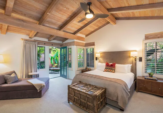 a bedroom with furniture and large windows