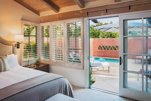 a bedroom with a bed and a large window with outer view
