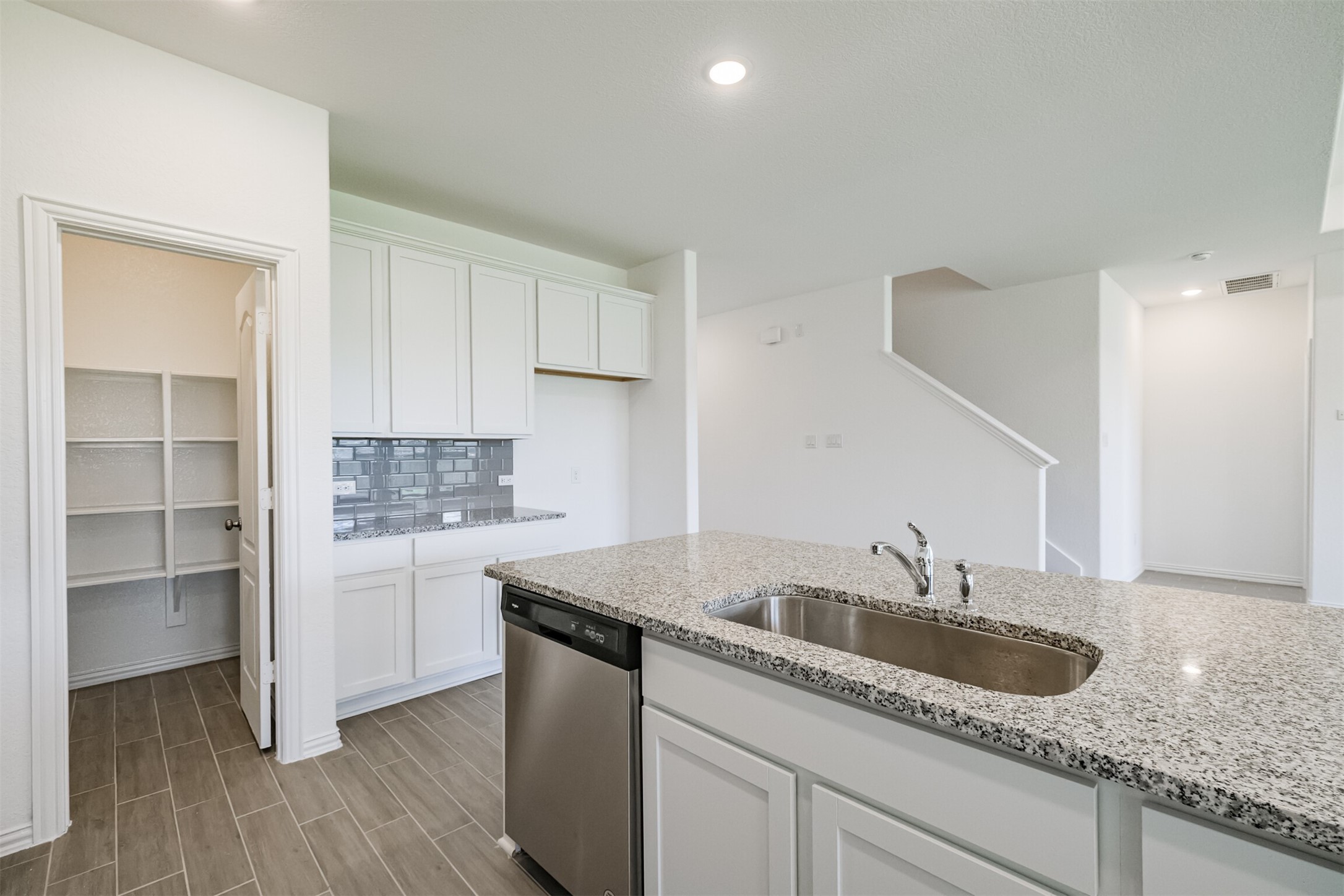 7922 Chukka Drive Fulshear, TX 77441 - Photo 11 of 39 a kitchen with granite countertop a sink a stove and cabinets