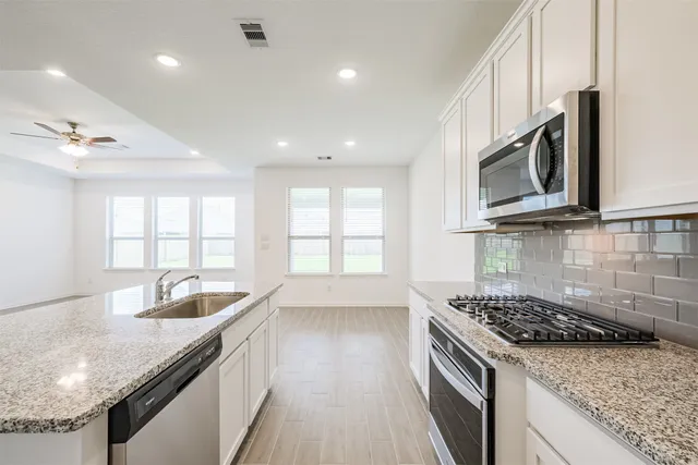 a kitchen with granite countertop a sink and stove top oven