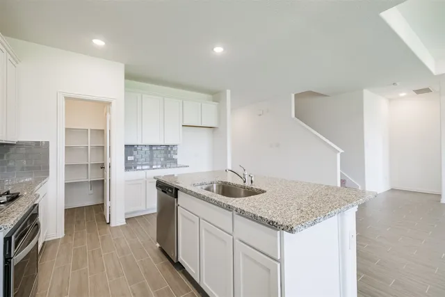 a kitchen with granite countertop a sink and stove