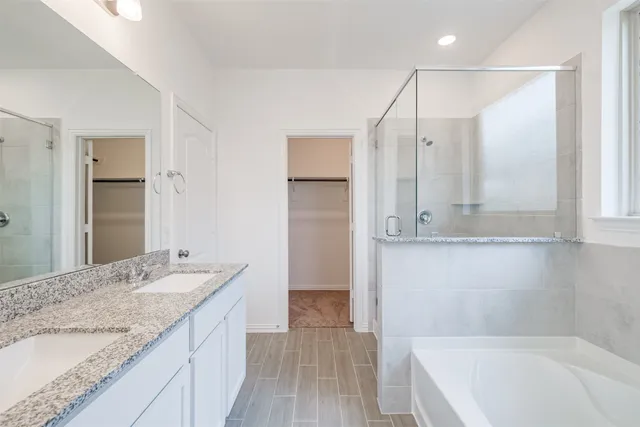 a bathroom with a granite countertop sink mirror and a bathtub