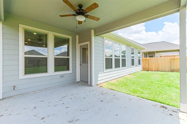 a view of an empty room with a window and kitchen view