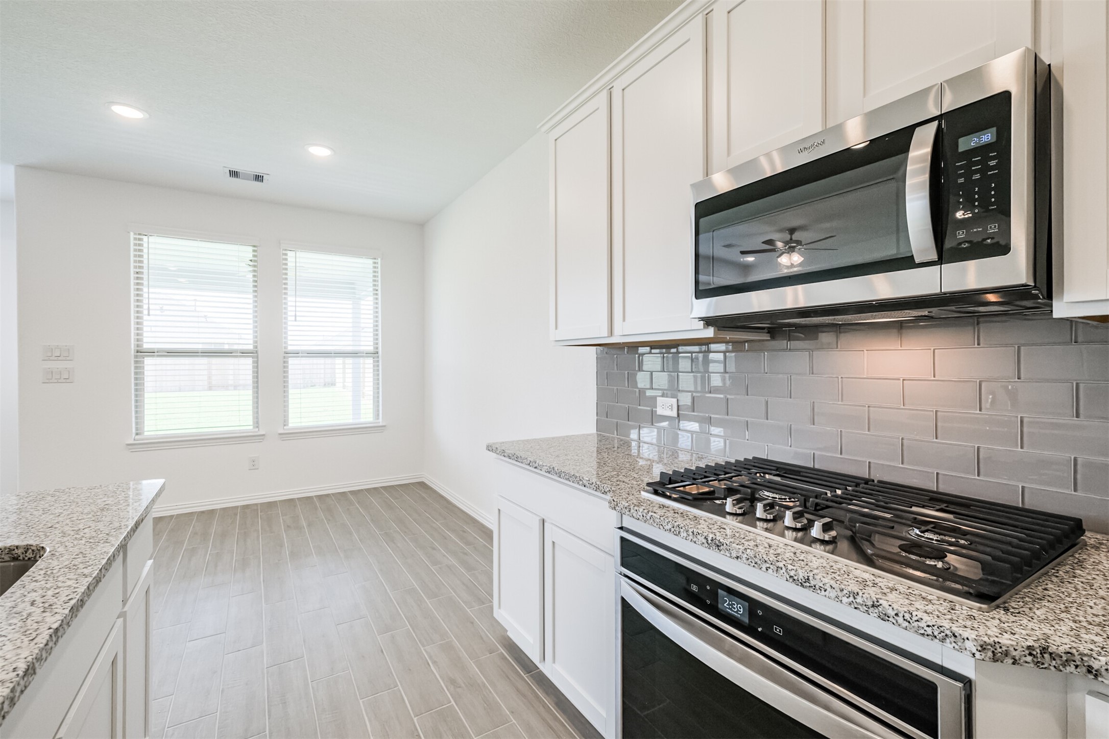 7922 Chukka Drive Fulshear, TX 77441 - Photo 5 of 39 a kitchen with a stove a microwave and window