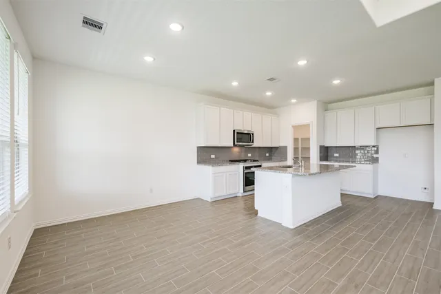 a kitchen with white cabinets and stainless steel appliances