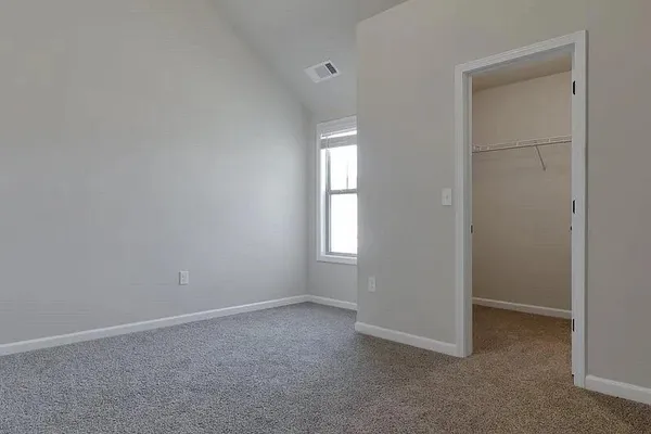 an empty room with windows and closet