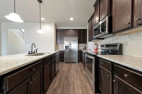 a kitchen with stainless steel appliances granite countertop a sink a stove and cabinets