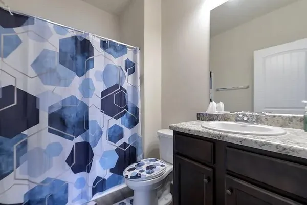 a bathroom with a sink and mirror with toilet