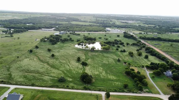 an aerial view of residential houses with outdoor space and trees