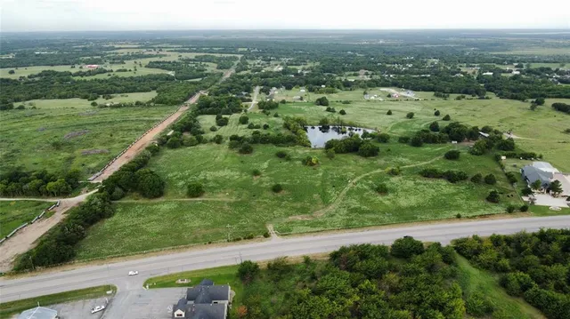 an aerial view of residential houses with outdoor space and trees
