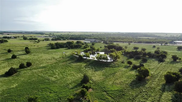 an aerial view of field with trees