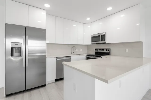 a kitchen with stainless steel appliances a refrigerator sink and microwave