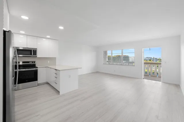 a kitchen with granite countertop a refrigerator and a stove top oven