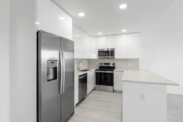 a kitchen with stainless steel appliances kitchen island a refrigerator sink and stove